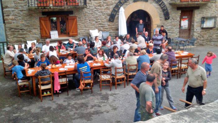 50 bat lagun mahaiaren bueltan, sardin jateaz gozatzen